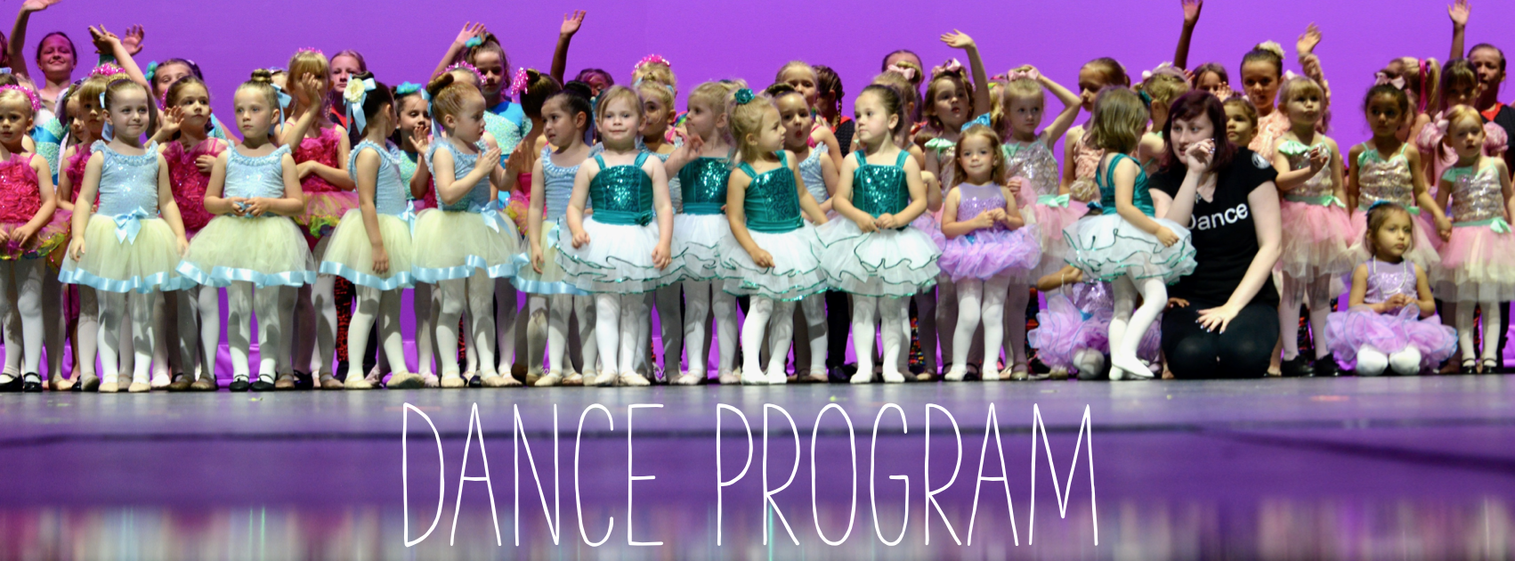 Dane program: Image of large group of young dancers on stage
