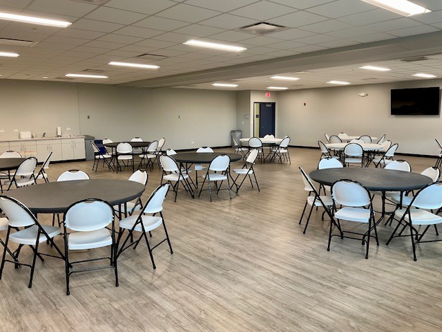 Expansive activity room and multiple tables and chairs 
