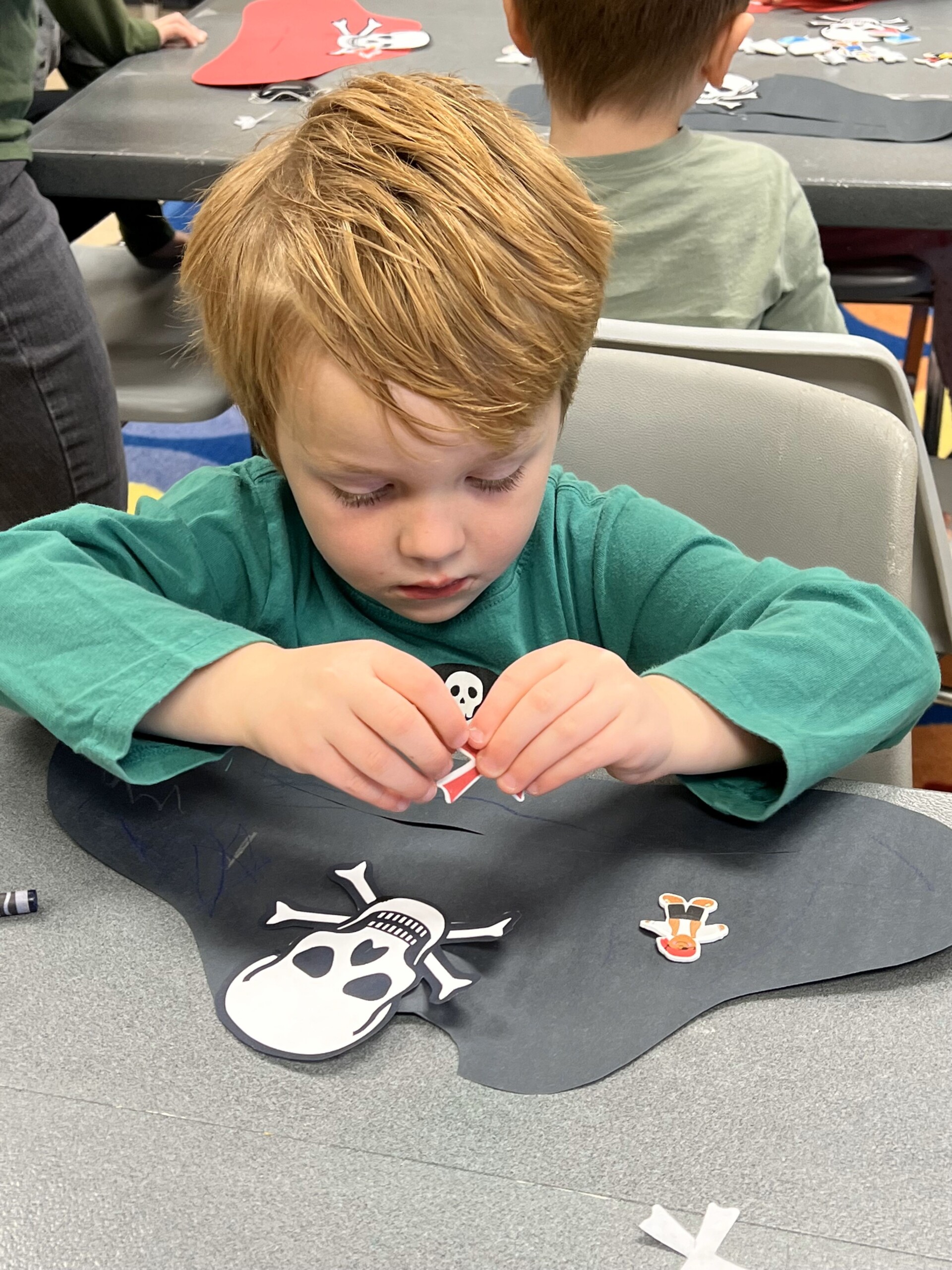 Young boy making a paper pirate hat