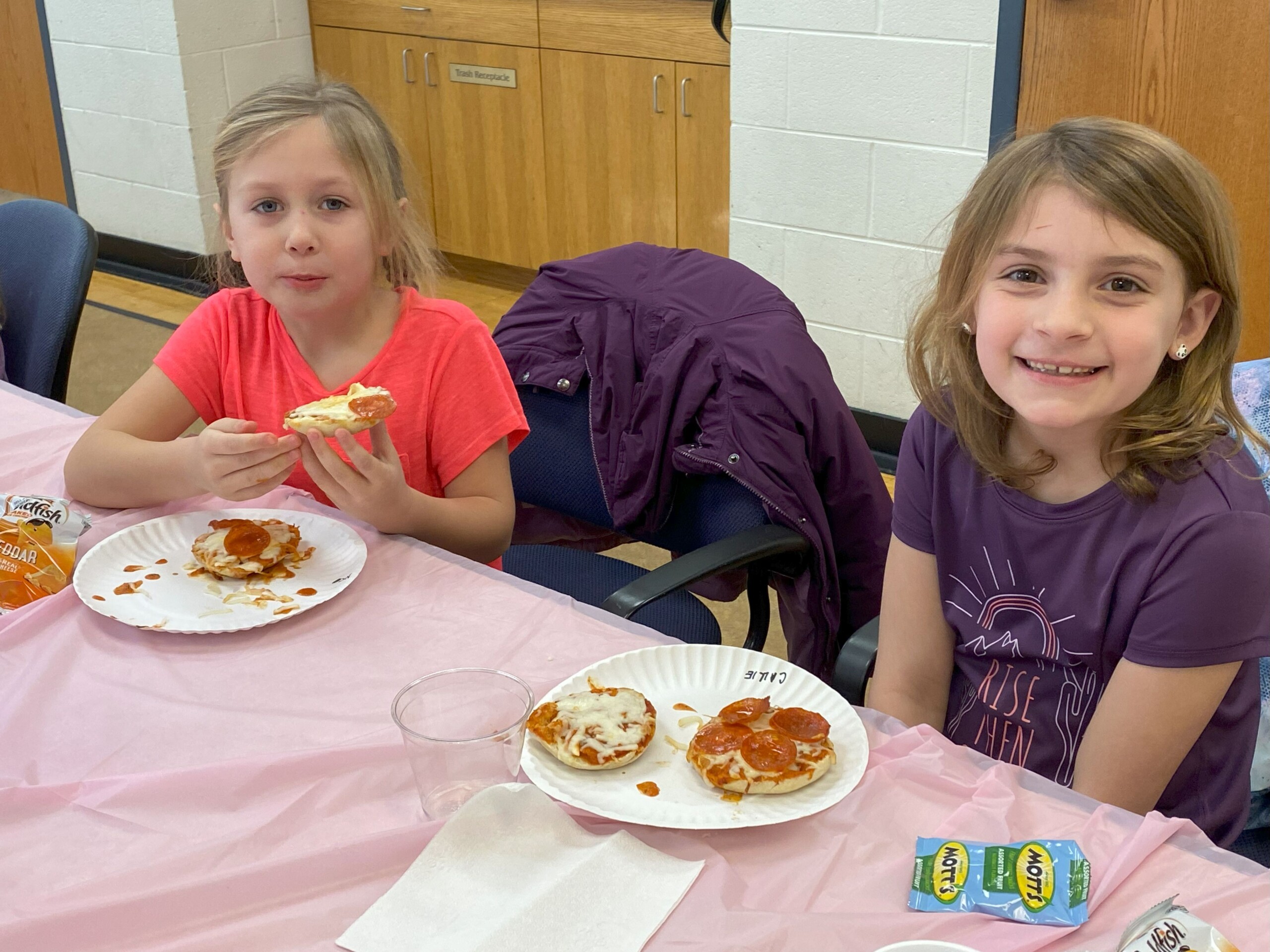 2 young girls enjoying a pizza party with snacks
