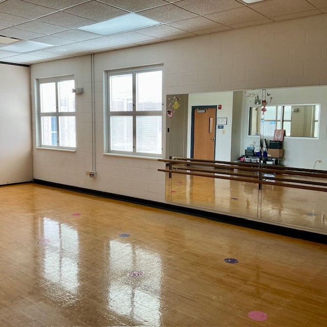 Studio with hardwood floor, mirrors and ballet barre